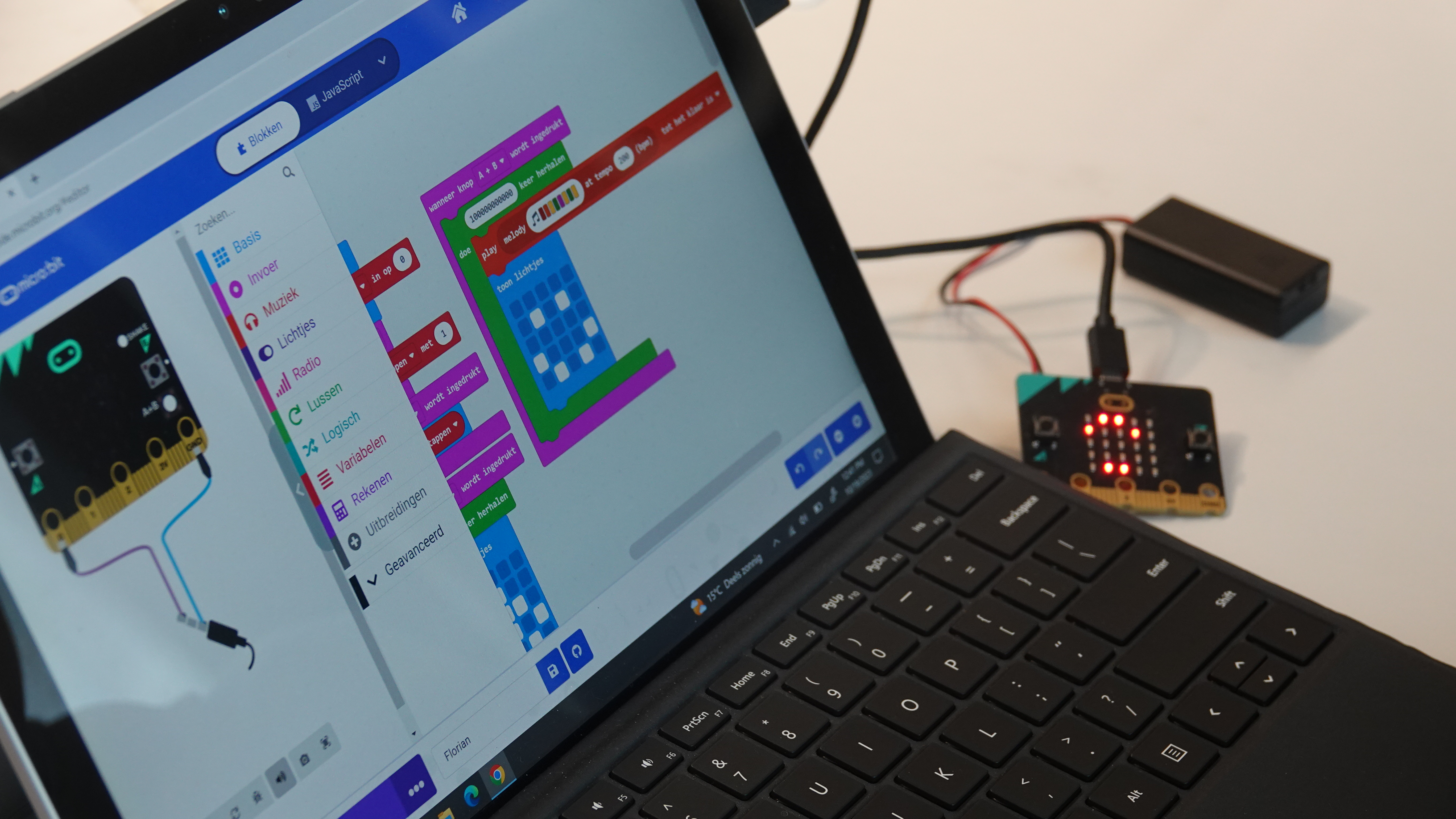 Een laptop met de MakeCode website en een micro:bit erop aangesloten